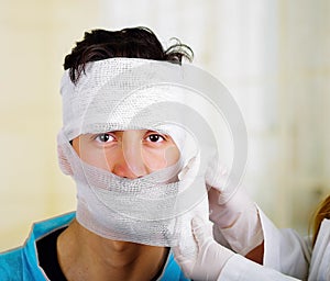 Doctor touching a men s head with trauma in his head and elastic bandaged around his head