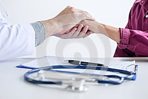 Doctor touching patient hand for encouragement and empathy on th