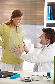 Doctor touching pregnant belly