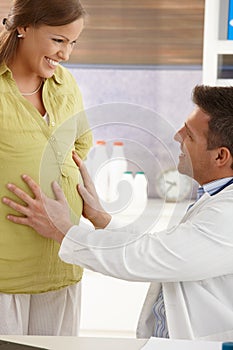 Doctor touching pregnant belly