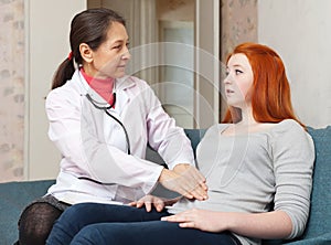 Doctor touching stomach of teenager