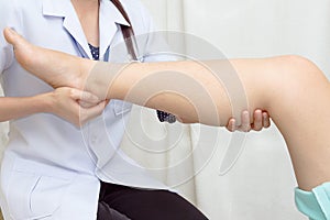 Doctor the traumatologist examines patient's knee photo