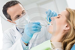 Doctor treats patient teeth in modern