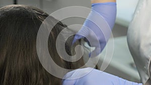 Doctor trichologist makes injections in woman`s skin on head for hair growth.