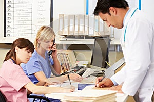 Doctor With Two Nurses Working At Nurses Station