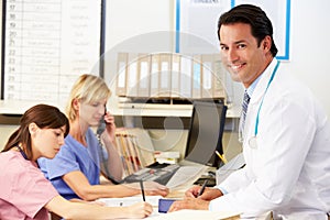 Doctor With Two Nurses Working At Nurses Station