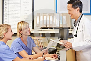 Doctor With Two Nurses Working At Nurses Station