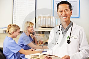 Doctor With Two Nurses Working At Nurses Station