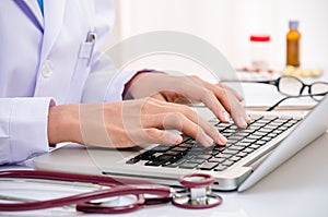 Doctor typing on computer