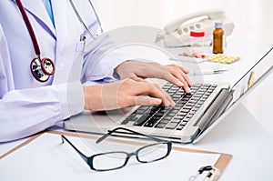 Doctor typing on computer