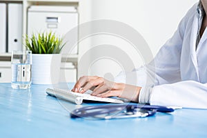 Doctor typing at computer keyboard