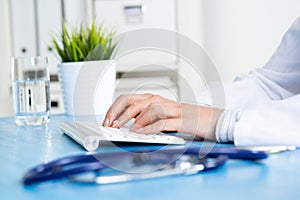 Doctor typing at computer keyboard