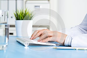 Doctor typing at computer keyboard