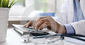 doctor typing on computer keyboard. working in clinic office. online medical consultation