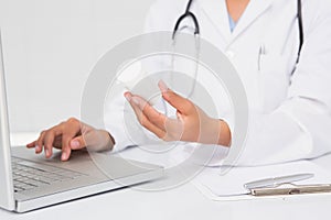 Doctor typing on keyboard the prescriptions