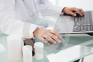 Doctor typing out prescriptions