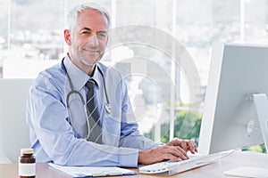 Doctor typing and using his computer