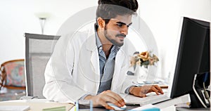 Doctor typing and using his computer
