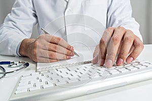 Doctor typing on wireless computer keyboard