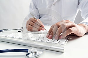 Doctor typing on wireless computer keyboard
