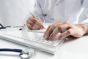 Doctor typing on wireless computer keyboard