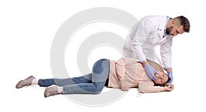 Doctor in uniform performing first aid on unconscious woman against white background