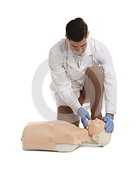 Doctor in uniform practicing first aid on mannequin against white background