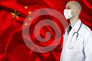 Doctor in uniform with a stethoscope and a mask on the background of the silk national flag of China, the concept of medical care