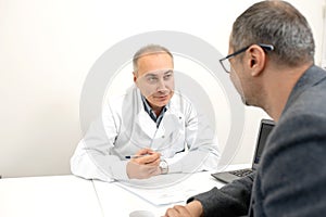 Doctor urologist advises a male patient in clinic