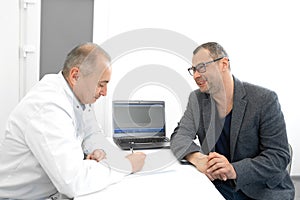 Doctor urologist advises a male patient in clinic photo