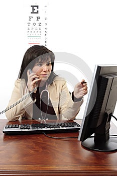 Doctor using computer and telephone