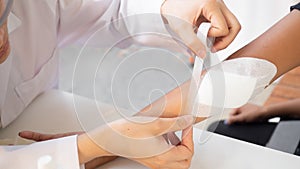 Doctor is using cotton dressing a wound at a women arm