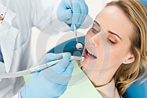 Doctor using dental drill during procedure in modern