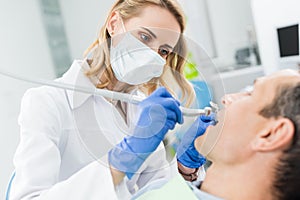 Doctor using dental drill during procedure in modern