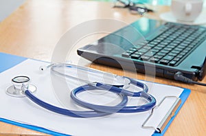 Doctor using digital labtop computer medical working information with stethoscope on desk