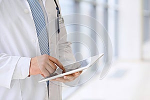 Doctor using a digital tablet, close-up of hands. Health care concept