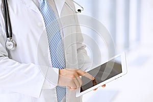 Doctor using a digital tablet, close-up of hands. Health care concept