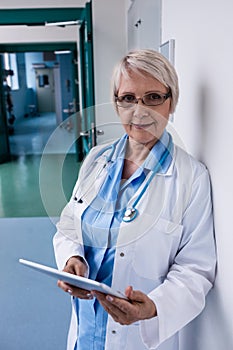 Doctor using digital tablet in corridor