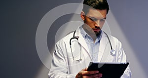 Doctor using digital tablet in corridor