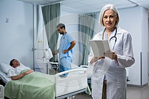 Doctor using digital tablet in ward