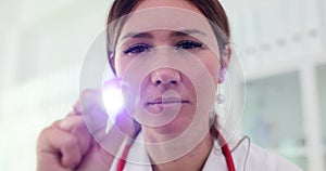 Doctor using a flashlight to examine patient eyes and reflexes