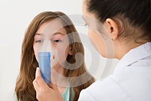 Doctor Using Inhaler Mask On Girl