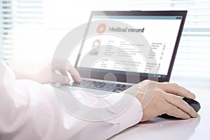 Doctor using laptop and electronic medical record EMR system. photo