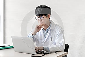 Doctor is using a notebook computer, In search of information And write a report about the patient`s condition