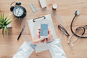 Doctor using smartphone app in hospital office