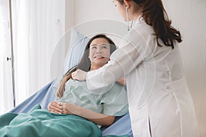 Doctor using stethoscope checking to asian women patient for listening heart rate on sickbed in hospital room