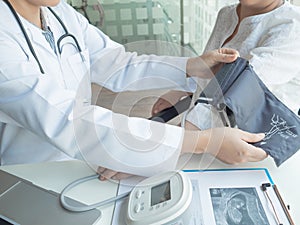 A doctor using stethoscope while examining a pregnant woman in a clinic