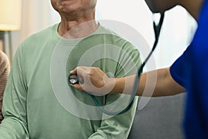 Doctor using stethoscope listening to mature male patient breath or heartbeat. Healthy care concept