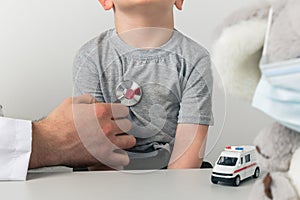 Doctor using stethoscope to check child`s health isolated in the cabinet.