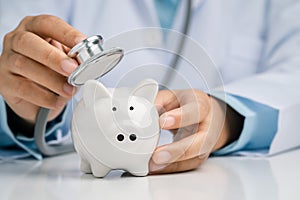 Doctor using a stethoscope to check the piggy bank financial check-up, Concept check financial sustainability of financial status